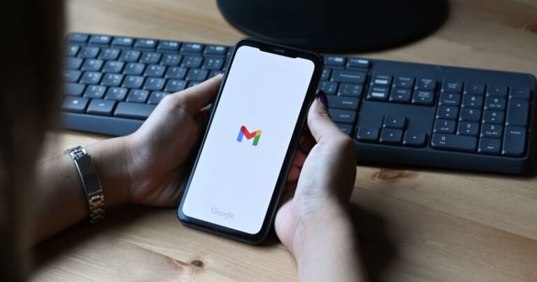 Smartphone tenuto in mano con l'app Gmail aperta — i punti negli indirizzi email Gmail